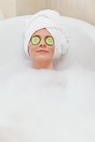 Relaxed woman taking a bath with a towel on her head 