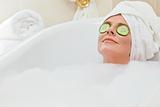 Relaxed woman taking a bath with a towel on her head