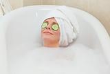 Relaxed woman taking a bath with a towel on her head 