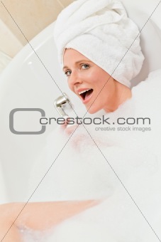 Charming woman taking a bath with a towel on her head
