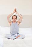 Man practicing yoga on his bed