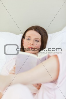 Woman reading a book on her bed