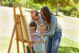 Family painting together in the park