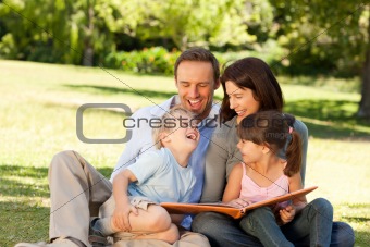 Family looking at their photo album in the park