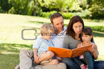 Family looking at their photo album in the park