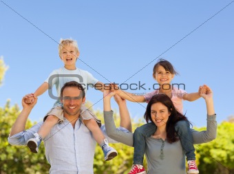 Parents giving  children a piggyback 