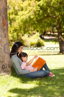 Mother with her daughter looking at their album photo