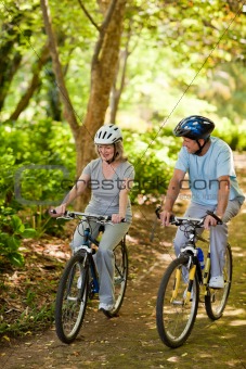 Elderly couple mountain biking outside