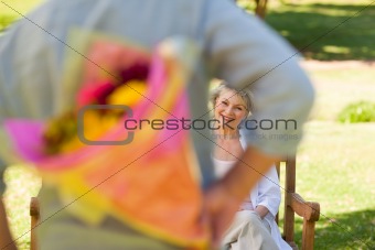 Mature man offering flowers to his wife