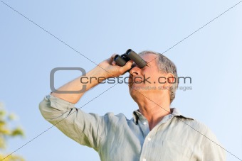 Man looking at the sky with his binoculars