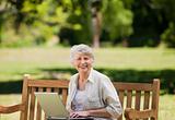 Mature woman working on her laptop on the bench
