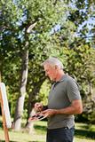 Mature man painting in the garden