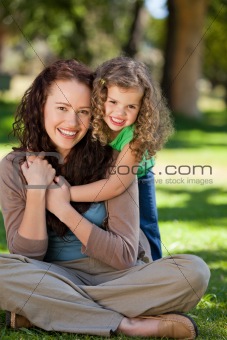 Woman hugging her daughter in the park