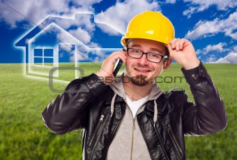 Contractor in Hard Hat on Cell Phone in Front of Ghosted House, Grass Field and Blue Sky with Clouds.