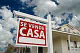 Se Vende Casa Spanish Real Estate Sign and House and Blue Sky with Clouds.