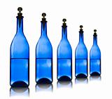 Five blue glass bottles with water