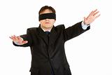Disoriented businessman with blindfold covering his eyes
