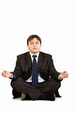 Meditating modern businessman sitting on floor
