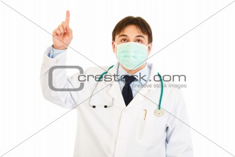 Medical doctor in mask pointing  finger up
