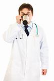 Medical doctor  in uniform drinking coffee
