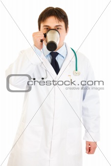 Medical doctor  in uniform drinking coffee
