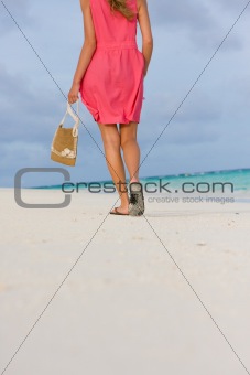 Young woman goes for a walk on a beach