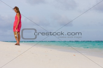 Young woman goes for a walk on a beach