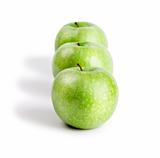 Three ripe and juicy green apples located in a line one after another isolated on a white background