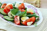 Salad with quail eggs and tomato on a plate