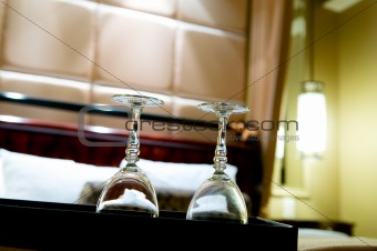 Two glasses on the double bed as romantic concept