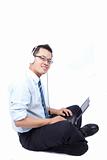 smiling young businessman sitting and using a laptop