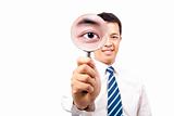young businessman holding Magnifier and show his big eye