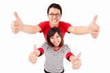 Excited young couple celebrating with thumb up
