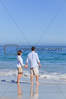 Couple walking on the beach under the sun