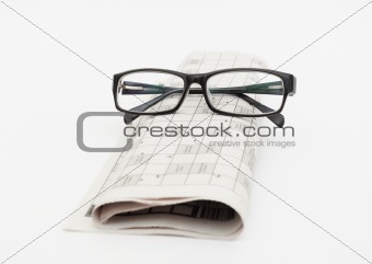 Reading glasses sitting on a newspaper