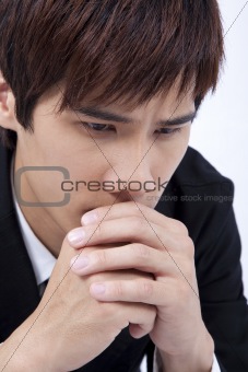Young and sad man praying