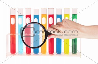 Various glass test tubes in holder and hand with magnifier isola