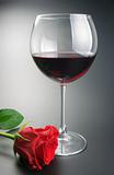 Glass of red wine and rose flower