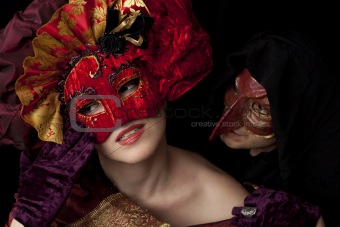 Woman and man wearing carnival masks