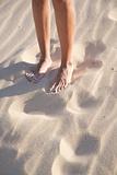 woman legs on sand beach