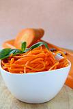 Carrot salad in white bowl  with basil
