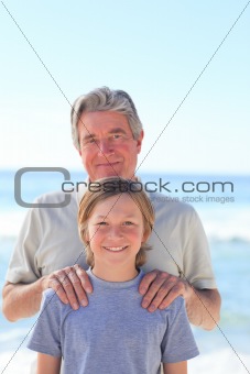 Grandfather with his grandson on the beach