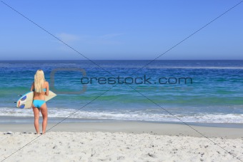 Beautiful blonde woman with her surfboard