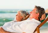 Elderly couple relaxing in their deck chairs