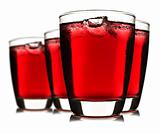 Four glasses of red fruit juice with ice