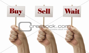 Three Signs In Male Fists Saying Buy, Sell and Wait Isolated on a White Background.