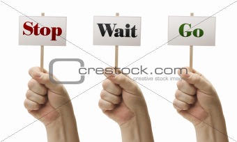 Three Signs In Male Fists Saying Stop, Wait and Go Isolated on a White Background.