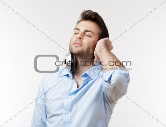 man in blue shirt with earphones listening to music - isolated on white