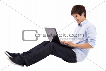 Happy and relax young man using laptop on the floor isolated on white background