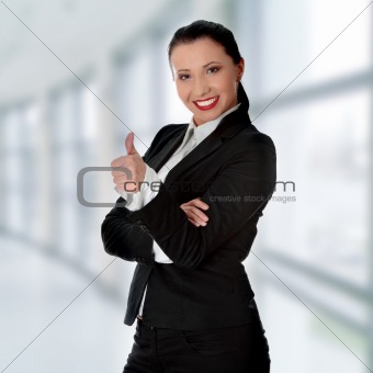 Confident business woman standing and gesturing ok